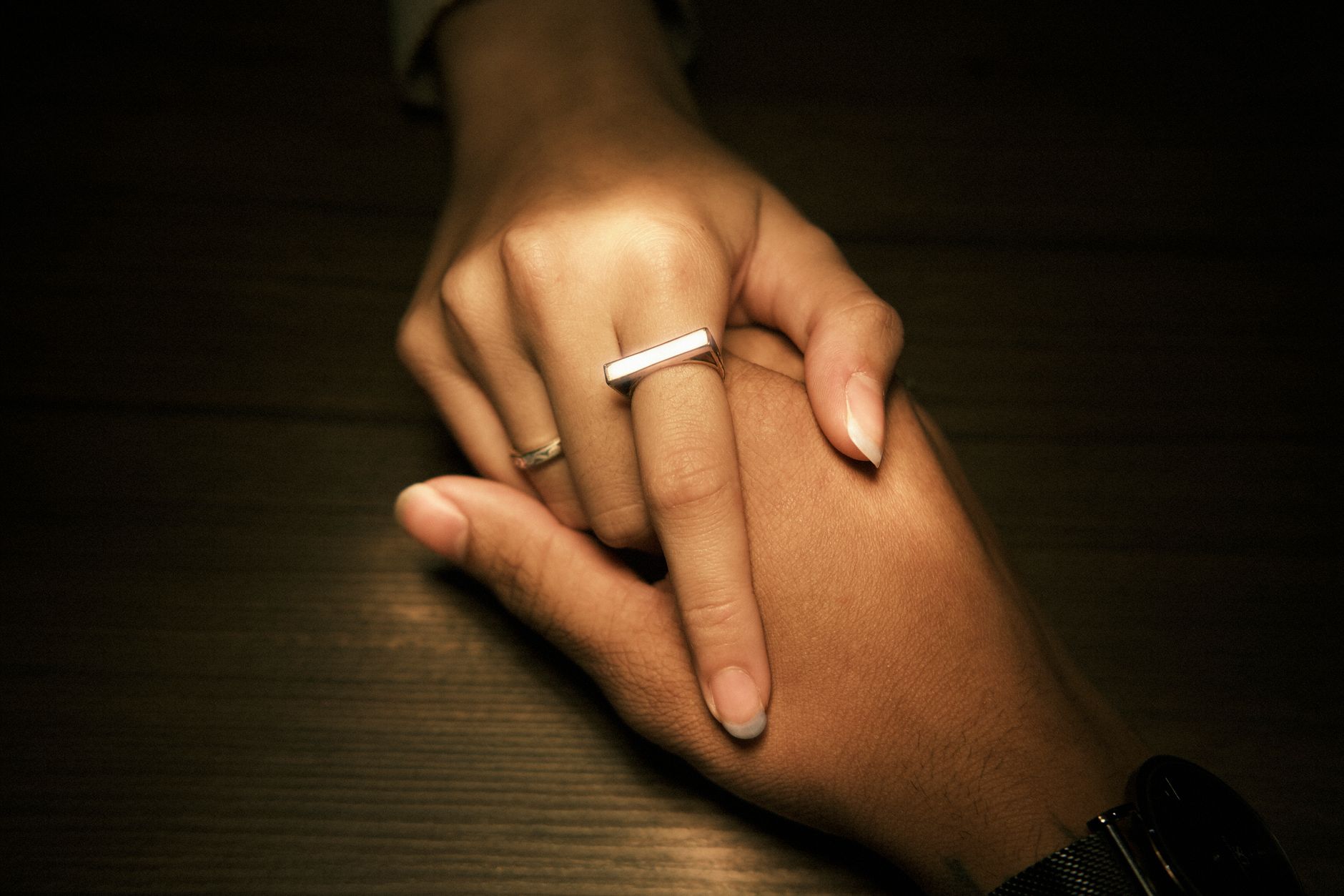 A sleek metallic smart ring worn on a person's index finger, showing a minimalist screen-free design.