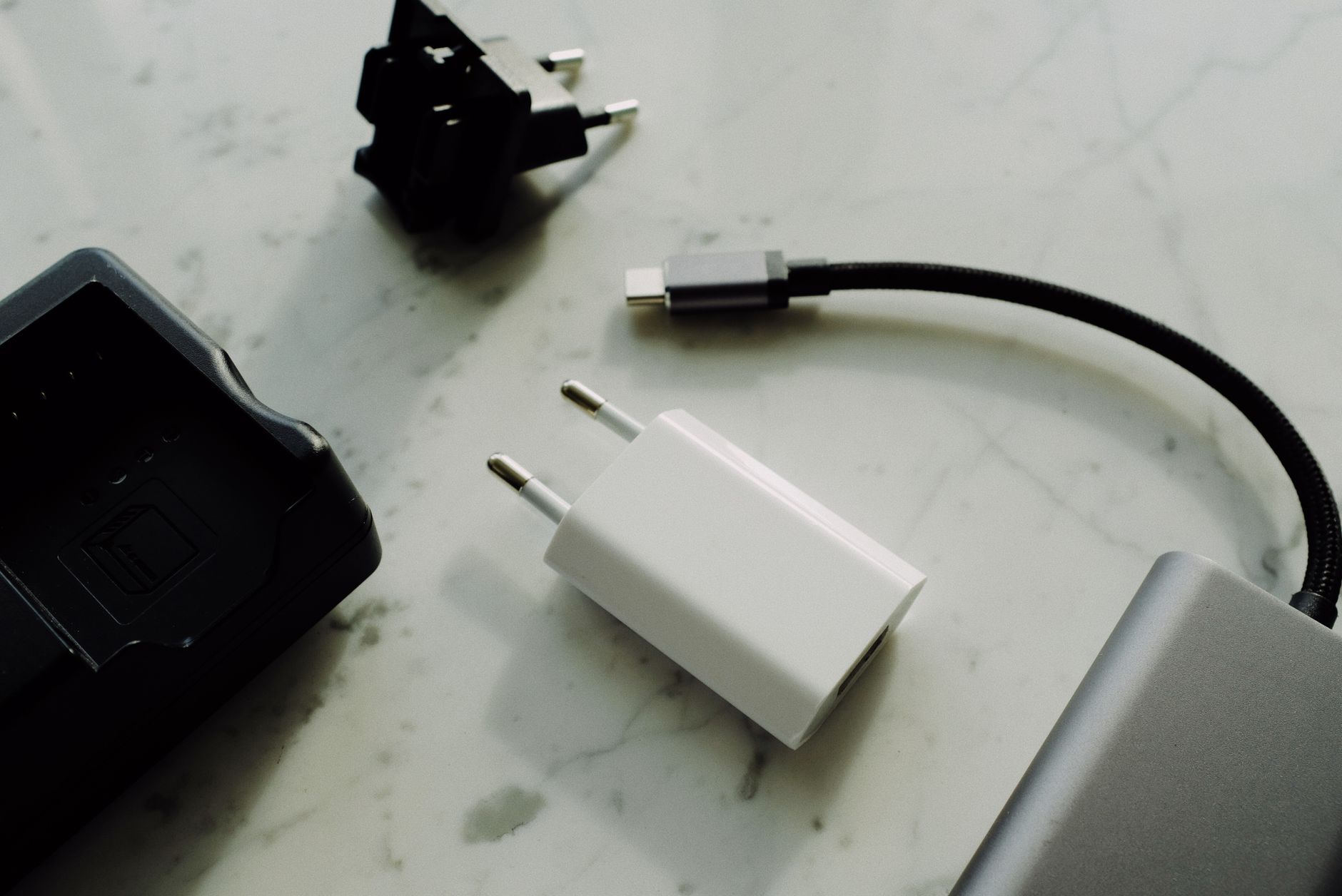 A collection of various USB-C cables arranged neatly on a wooden desk showing different connector ends and cable thicknesses.