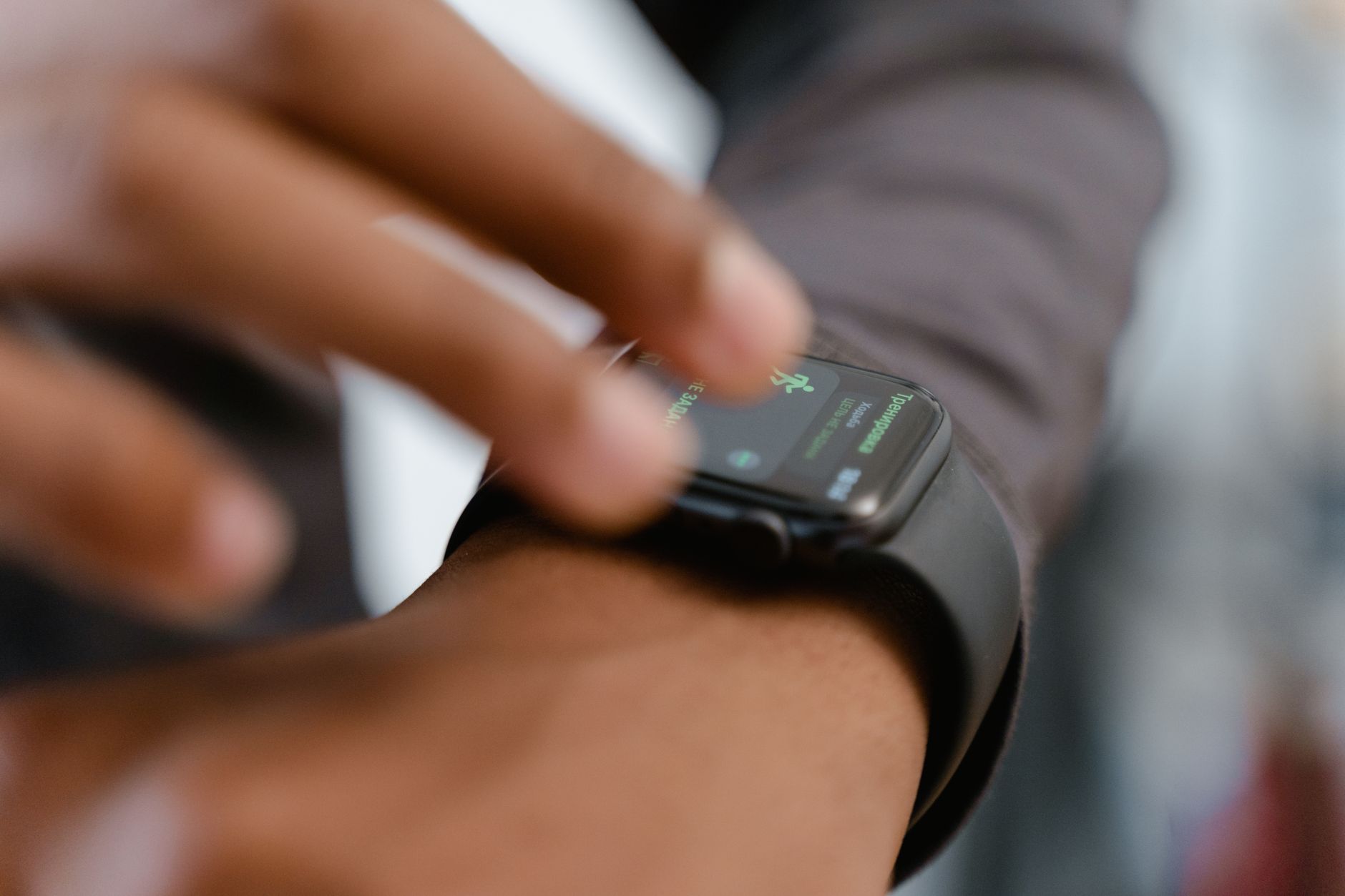 person wearing smartwatch running outdoors