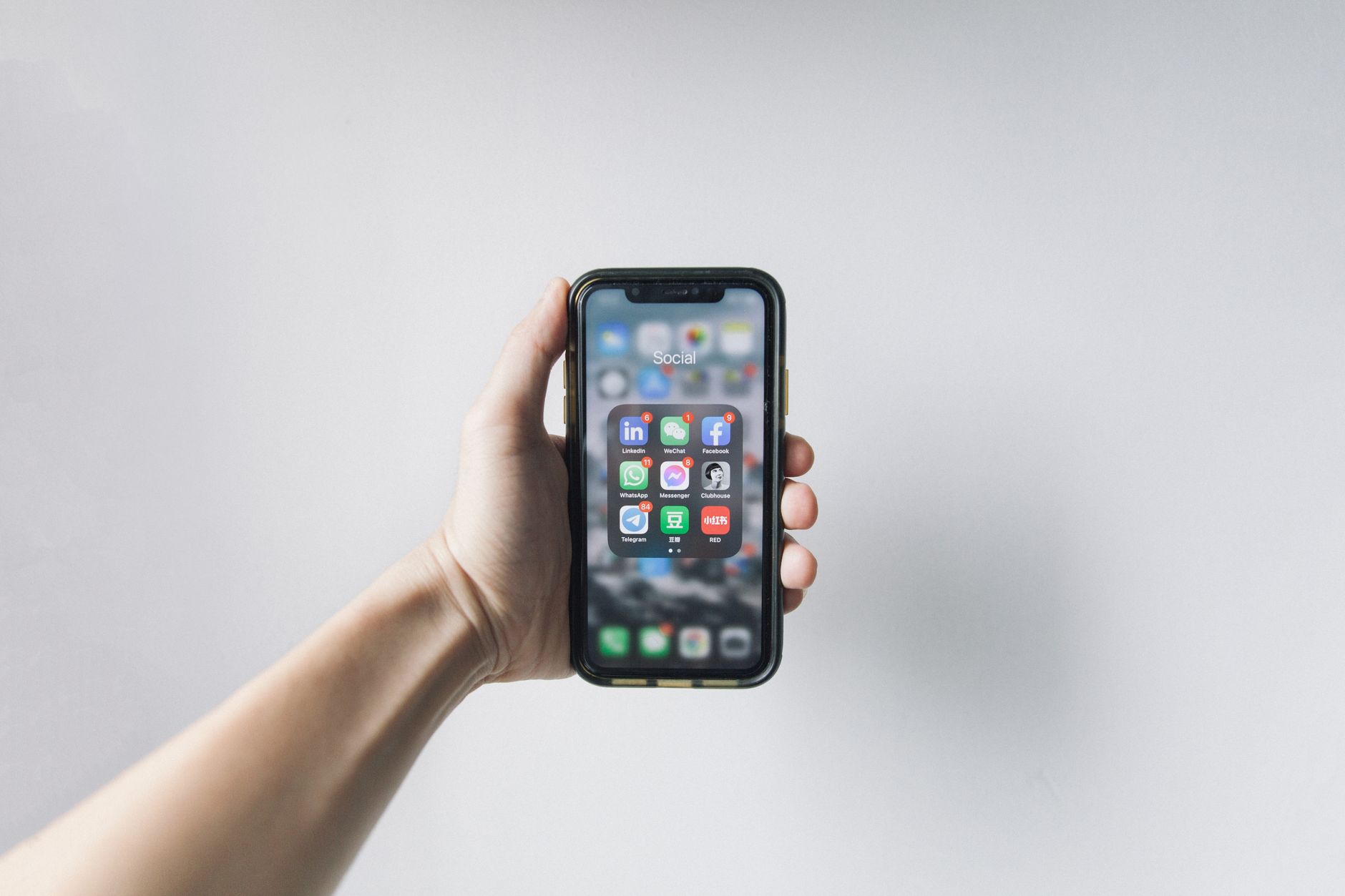 Person holding a smartphone displaying an image gallery in Google Photos with backup icons